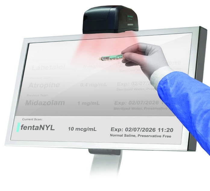 A clinician scans a prepared syringe label with SLS-WAVE beside an administration monitor